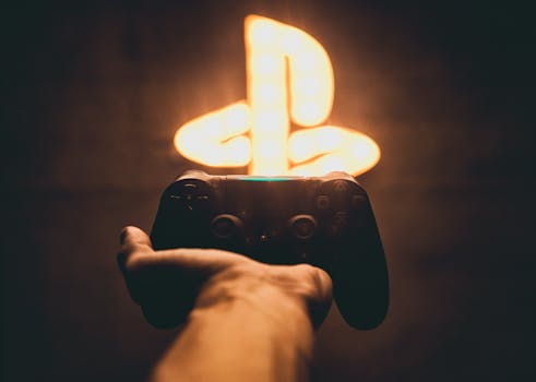 A hand holds a game controller with a glowing neon gaming symbol in the background, creating a vibrant gaming vibe.