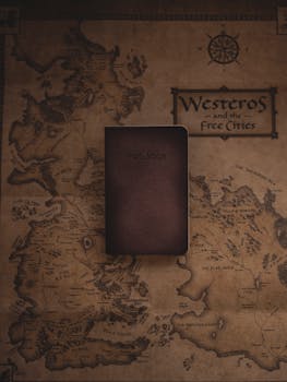 A leather notebook placed on a stylized map of Westeros from a fictional fantasy world.