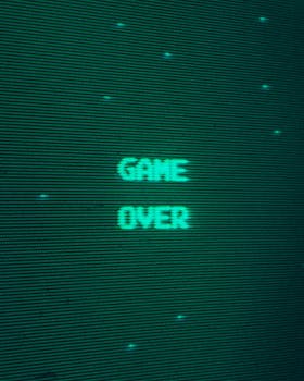 Close-up of a retro arcade game 'Game Over' screen in green, evoking classic gaming nostalgia.