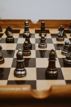 Close-up of a wooden chess board with metallic pieces, highlighting strategy and leisure.