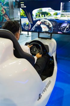 Man using PlayStation racing simulator at technology exhibition, showcasing gaming technology.